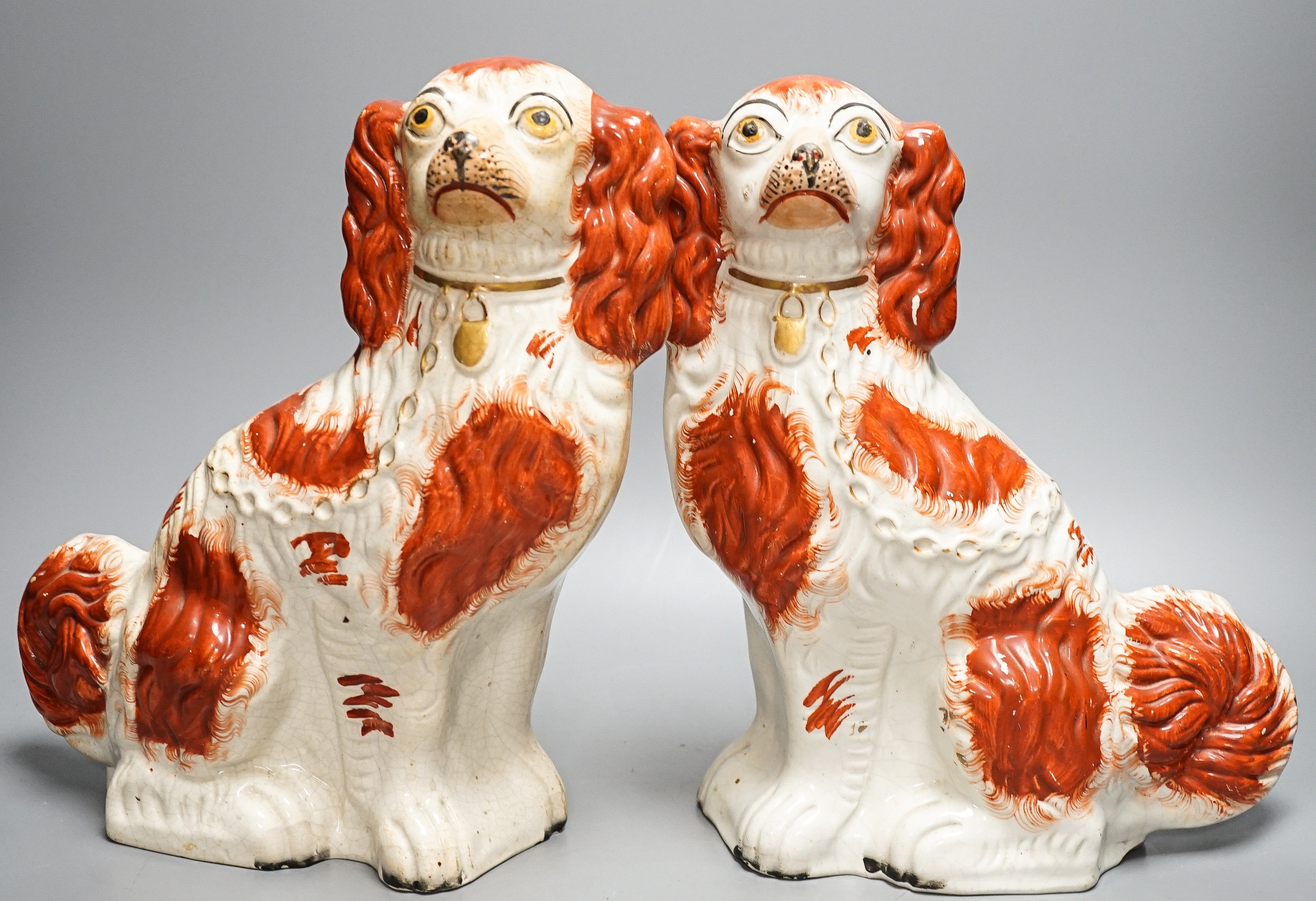 A pair of Victorian Staffordshire Spaniel chimney dogs and a greyhound, chimney dogs 31 cms high.